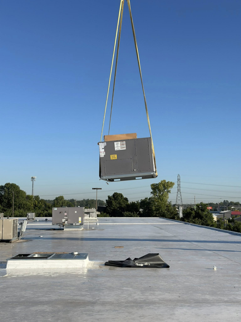 A new commercial HVAC unit being carefully craned onto a rooftop by Air Conditioning Experts in Orlando, FL.