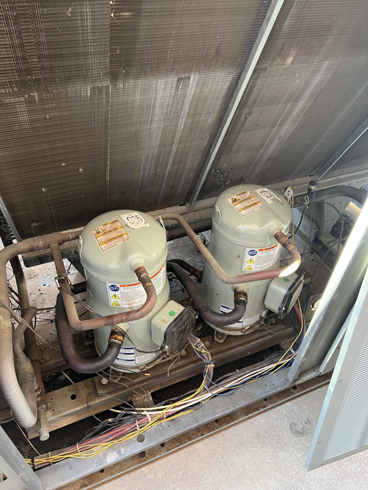Two compressors inside a commercial HVAC unit serviced by Evans Heat & Air in Ruther Glen, VA.