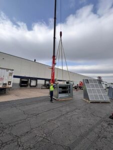 A large commercial HVAC unit being installed by crane with A All Temp Inc. Heating & Cooling in Naperville, IL.