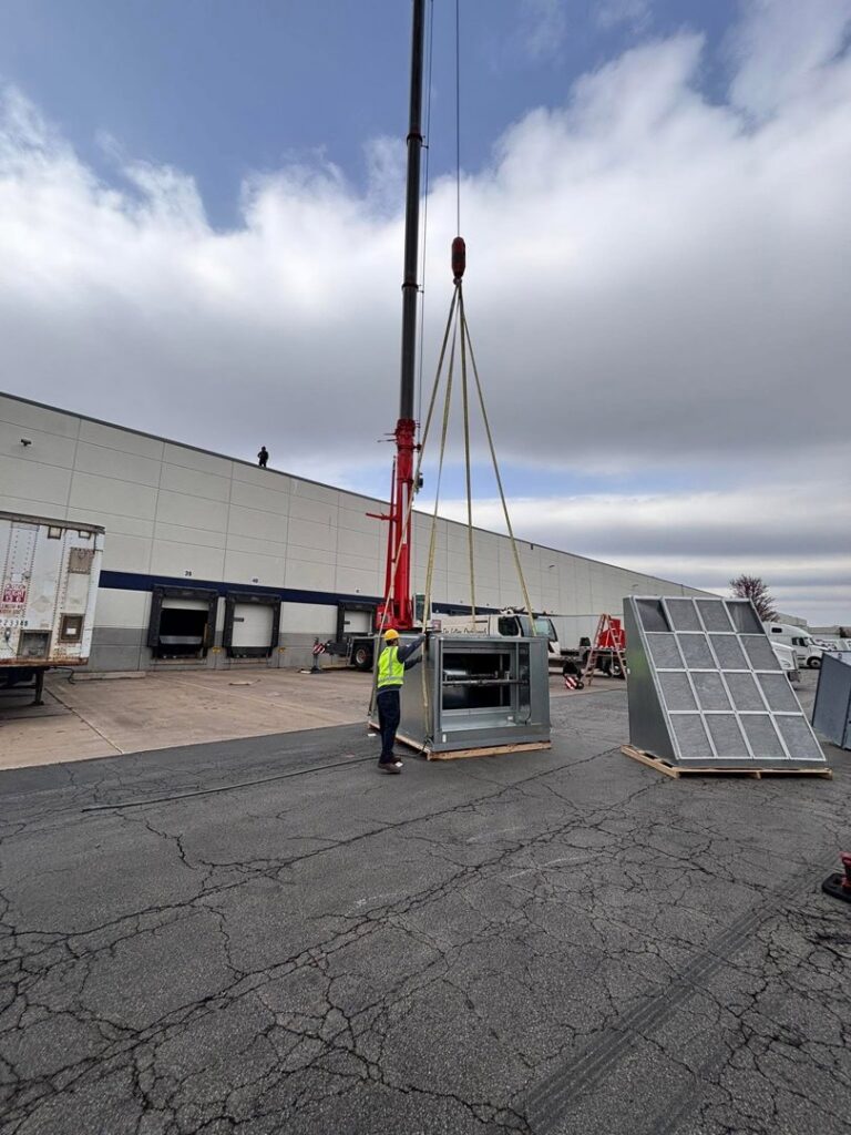 A large commercial HVAC unit being installed by crane with A All Temp Inc. Heating & Cooling in Naperville, IL.