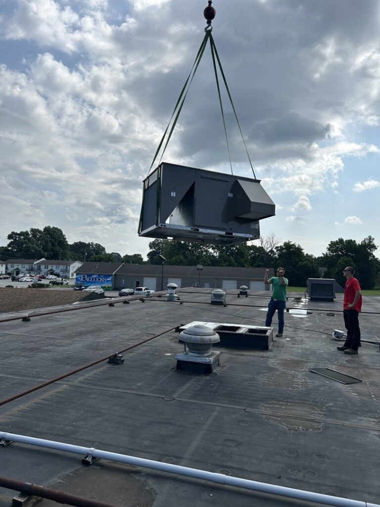 A commercial HVAC unit being installed by crane on a rooftop by Allegiance Heating & Air in Greenville, IN.