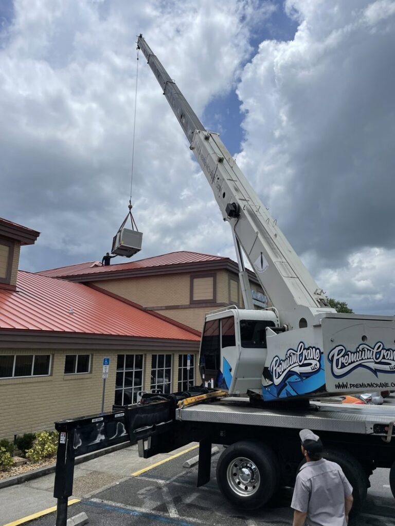 A crane lifting a new commercial HVAC unit onto a rooftop for installation by Blue Air Heating and Cooling in Orlando, FL.