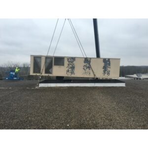 A large commercial HVAC unit being lifted by a crane onto a rooftop for installation by Ware's Heating & Cooling in Georgetown, KY.