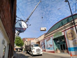 A crane lifting a commercial HVAC unit over a building for installation by Benck Mechanical Inc in Somerset, WI.