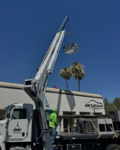 A commercial HVAC unit being lifted by a crane onto a building for installation by Cool Camel HVAC in Henderson, NV