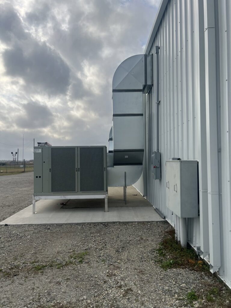 A large commercial HVAC unit with extensive ductwork installed on the side of a building by Alpha HVAC LLC in Alexandria, LA.