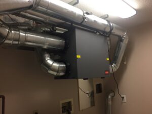 A commercial HVAC unit and ductwork installed in a utility room by Stanton Home Comfort in Fordland, MO.