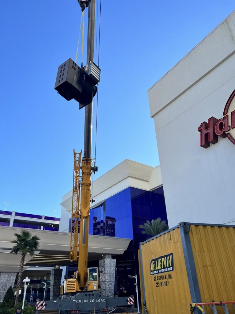 A crane lifting a large commercial HVAC unit during installation at a building by Anderson Mechanical Inc. in Pascagoula, MS
