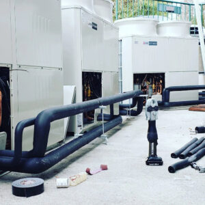 Commercial HVAC unit installation with piping and tools on a rooftop by GreenFlow Heating & Cooling in Tacoma, WA