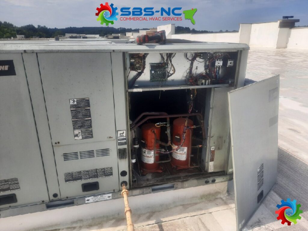 Internal components of a commercial HVAC unit, showing compressors, serviced by SBS-NC, LLC in High Point, NC.
