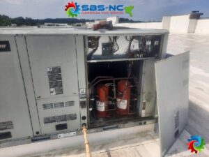 Internal components of a commercial HVAC unit, showing compressors, serviced by SBS-NC, LLC in High Point, NC.