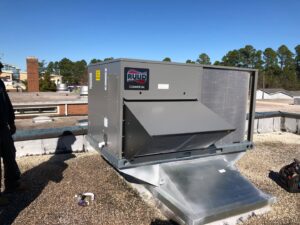 A new Ruud commercial HVAC unit installed on a rooftop by Deon Arnold Heating & Air Conditioning in Fayetteville, NC