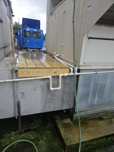 A large commercial HVAC unit with a newly built wooden platform and piping, installed by Capitol Heating and Air in Morgantown, PA.