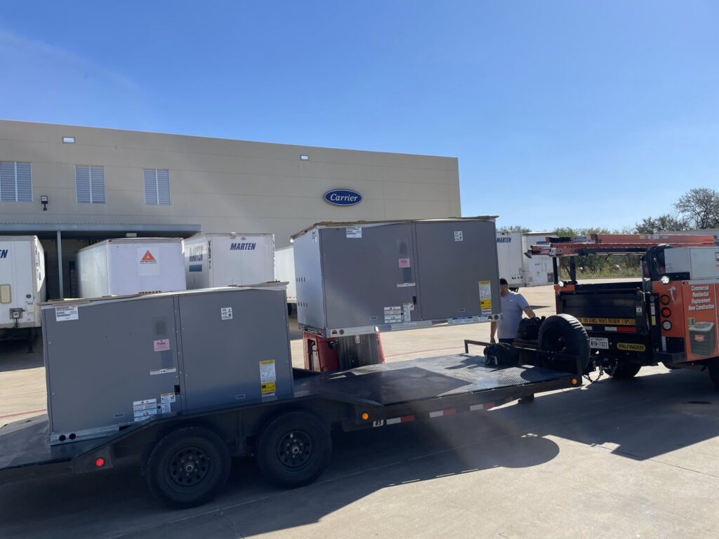 Large commercial HVAC units unloaded from a trailer with a forklift for installation by Benavidez Heating & Air Conditioning In, Arlington, TX.