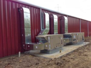 Multiple commercial HVAC units and ductwork installed next to a building by AireCom HVAC in Columbus, OH.