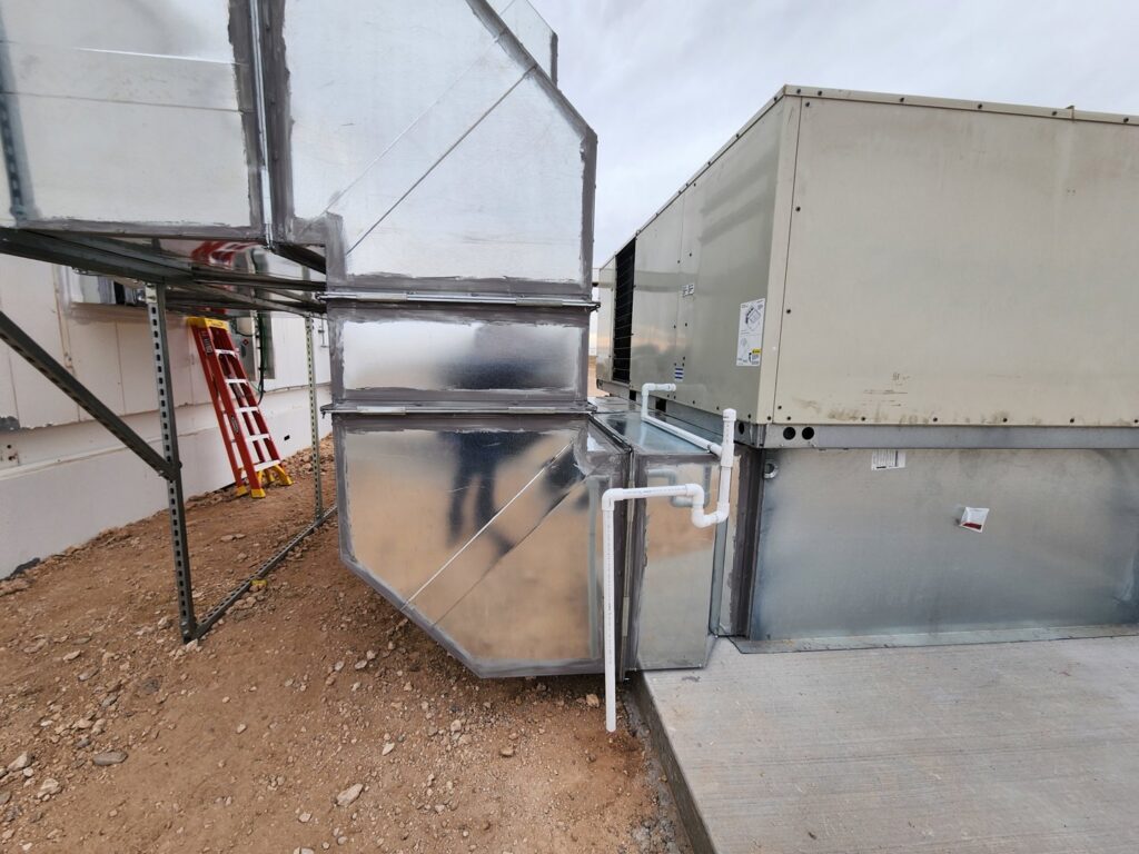 Commercial HVAC units and ductwork installed next to a building by Dynamic Heating, Cooling, Refrigeration & Roofing in El Paso, TX.