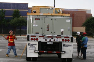 Commercial HVAC units loaded on a trailer with workers, ready for installation by Chapman Air and Heat in Dallas, TX