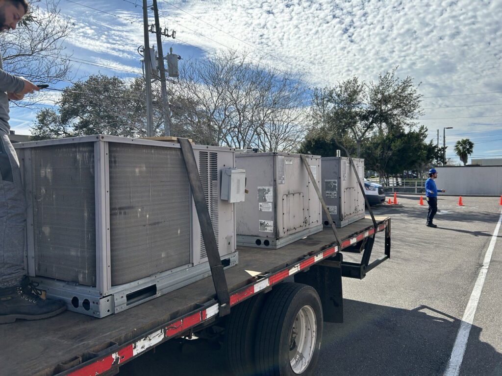 Multiple commercial HVAC units loaded onto a flatbed truck for delivery by Air Zero in Largo, FL