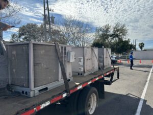 Multiple commercial HVAC units loaded onto a flatbed truck for delivery by Air Zero in Largo, FL