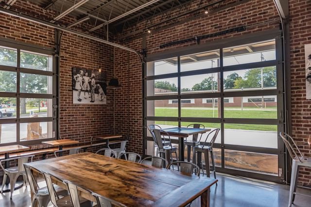 An interior view of a commercial space with a full-view glass garage door installed by Monroe Overhead Doors in Monroe, LA.