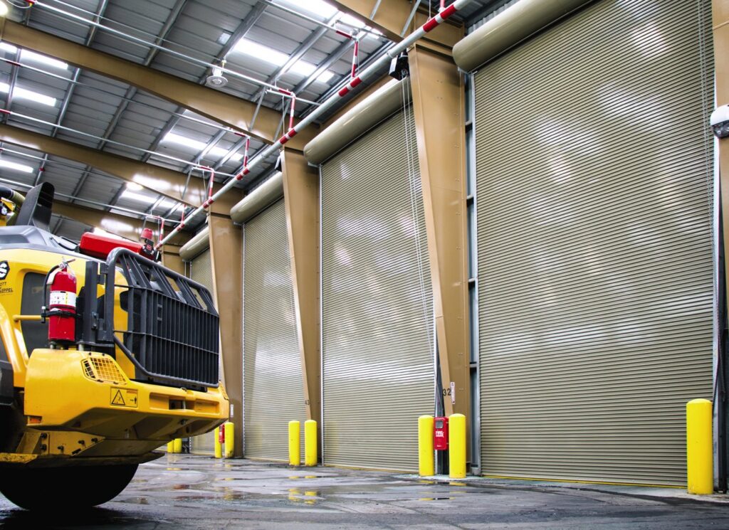 The interior of a commercial facility featuring large roll-up doors installed by Fort Wayne Door & Dock, Inc. in Fort Wayne, IN