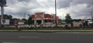 A black ornamental iron fence with brick pillars installed around a commercial property by Texas Fence and Iron Co. in Houston, TX.