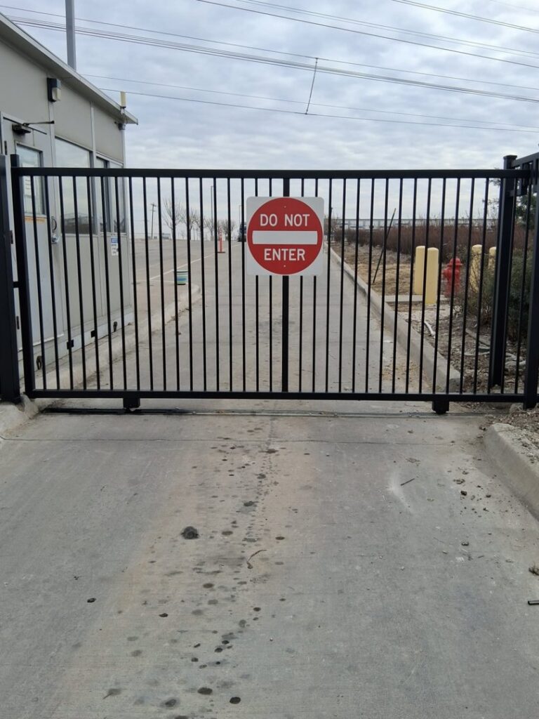 A commercial iron gate with a 'Do Not Enter' sign, installed by Iron Fence Services, LLC in Lancaster, TX.