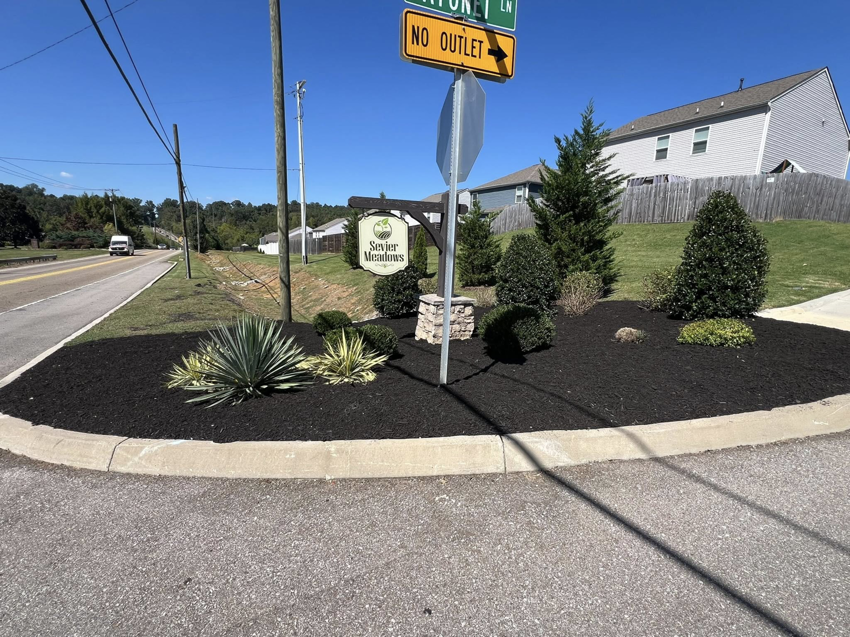 Commercial landscaping at a community entrance with fresh mulch by All Things Lawncare in Knoxville, TN.