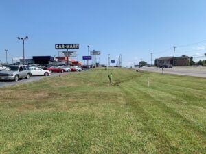 A commercial lawn maintenance crew working on a large grassy area by Cutting Edge Lawn Services in Islip, NY