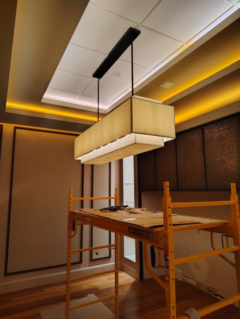 Installation of a large commercial light fixture using scaffolding, performed by Envision Electrical Solutions in Fort Lauderdale, FL.