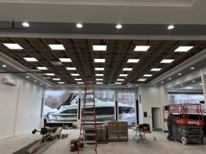 Commercial lighting installation in progress at a showroom, featuring square panel lights by RTF Electric LLC in Toms River, NJ.