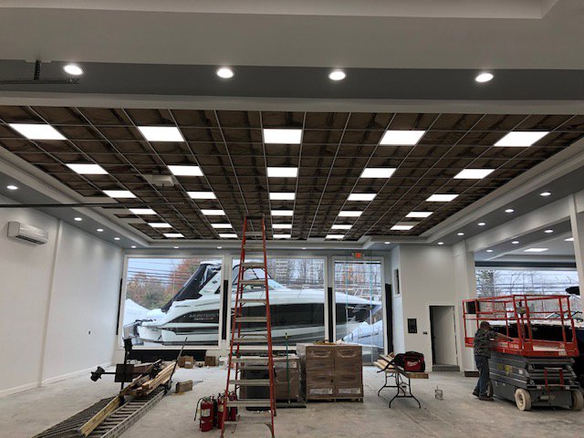 Commercial lighting installation in progress at a showroom, featuring square panel lights by RTF Electric LLC in Toms River, NJ.