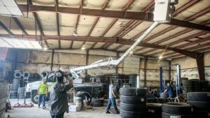 Electricians from Lumenus Technologies, LLC installing commercial lighting in a warehouse in Lenexa, KS.