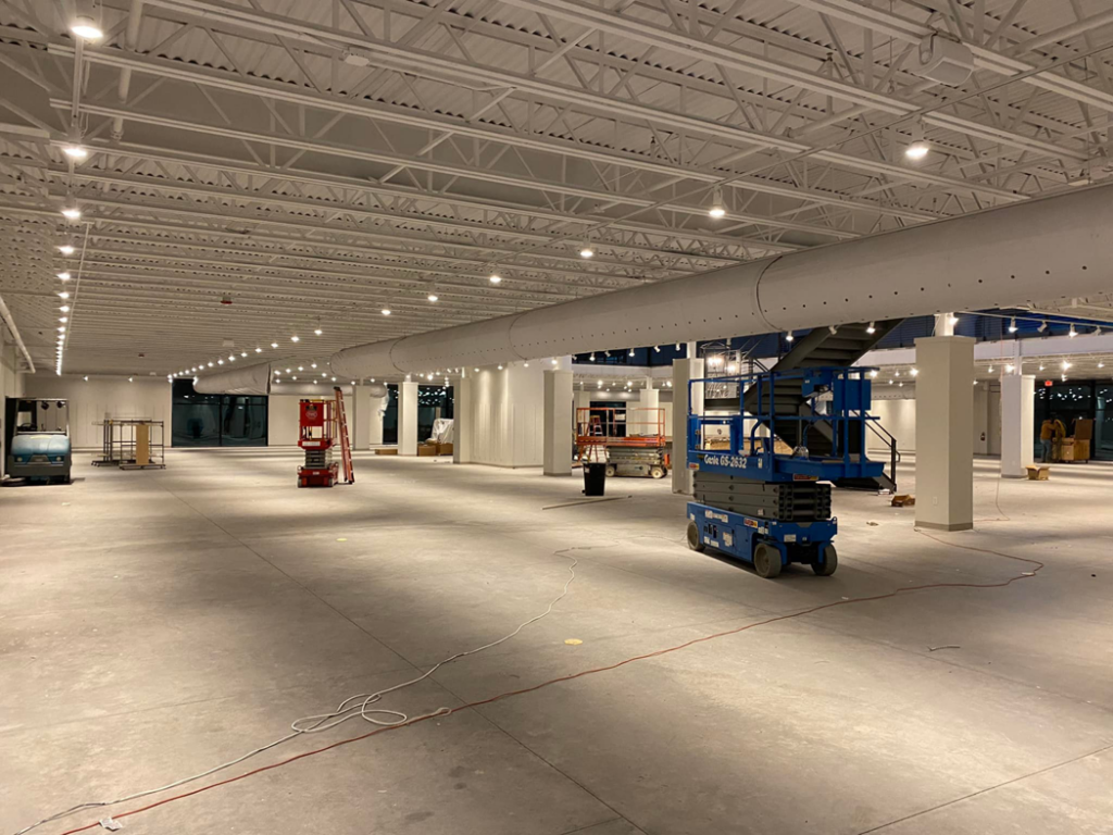 A large commercial space showing an electrical lighting project with scissor lifts by McCormick Wiring Co. LLC in Polkton, NC.