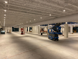 A large commercial space showing an electrical lighting project with scissor lifts by McCormick Wiring Co. LLC in Polkton, NC.