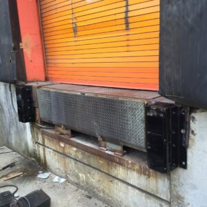A commercial loading dock with an orange rolling door and dock bumpers installed by Universal Overhead And Garage Doors in Baltimore, MD.