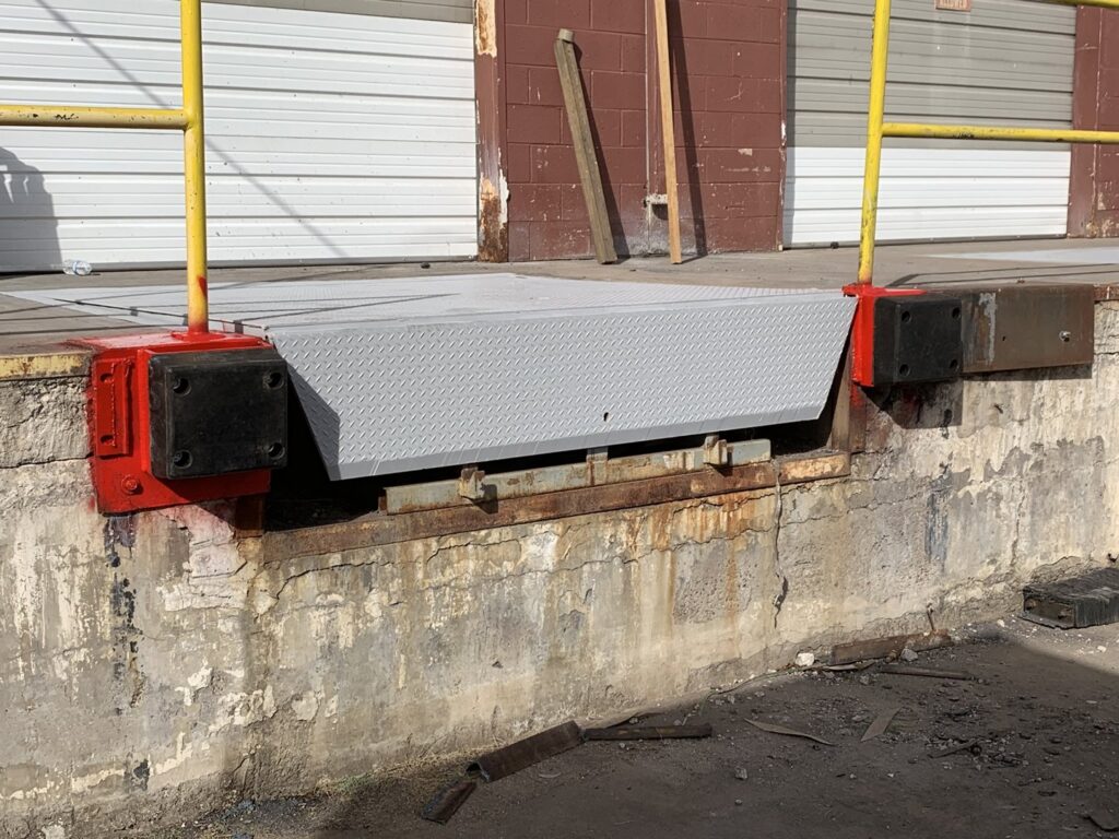 A commercial loading dock area with multiple garage doors in the background, serviced by Fix It Now Garage Doors.com in Tempe, AZ.