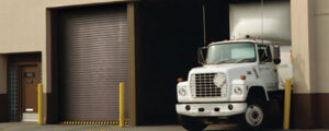 A commercial loading dock with a roll-up garage door and a truck by Overhead Door Company of Knoxville in Knoxville, TN
