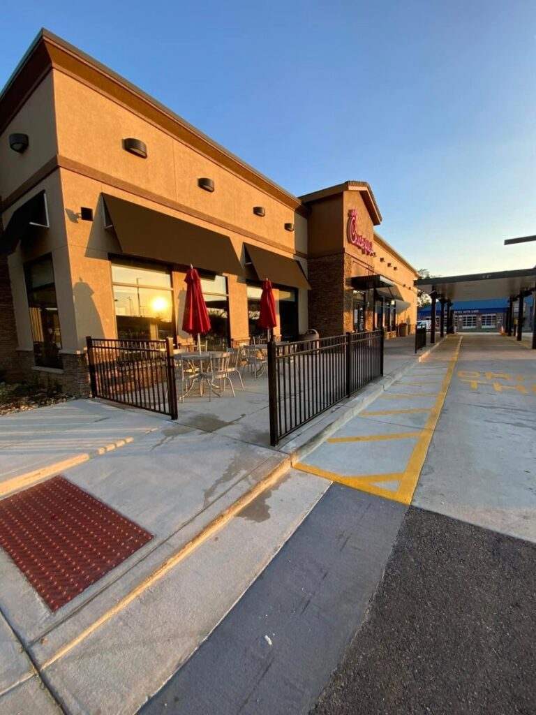 A commercial black metal railing installed around an outdoor seating area at a Chick-fil-A by TC Fencing LLC in Tuscaloosa, AL.