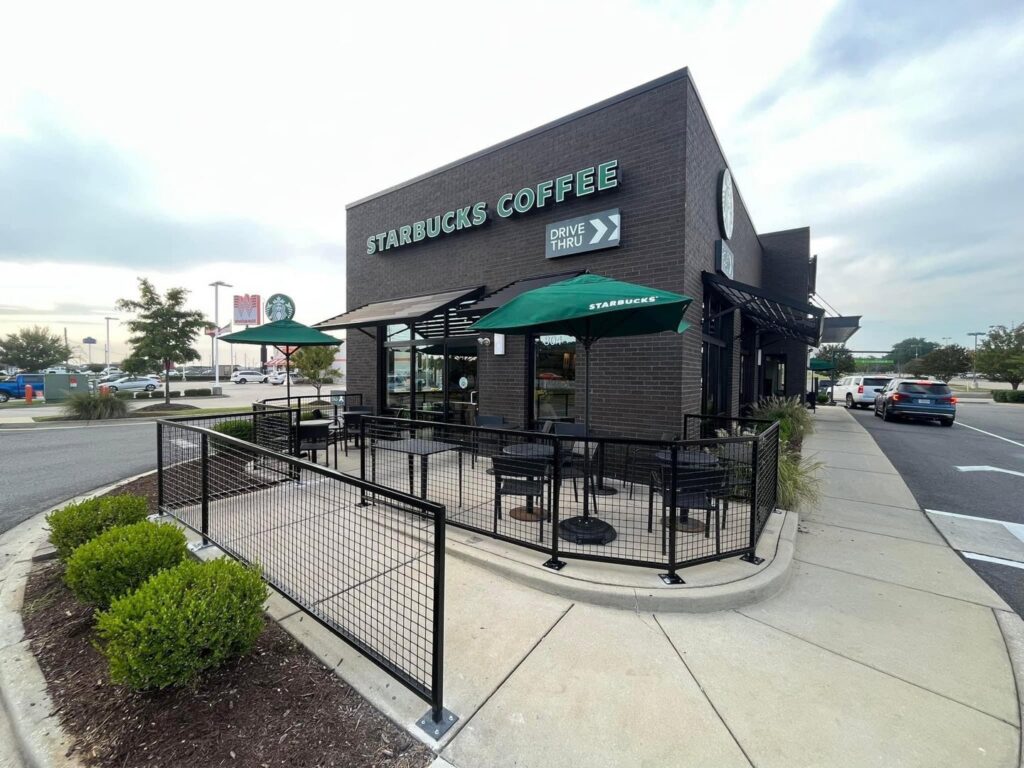 A commercial black metal railing installed around an outdoor seating area at a Starbucks by TC Fencing LLC in Tuscaloosa, AL.