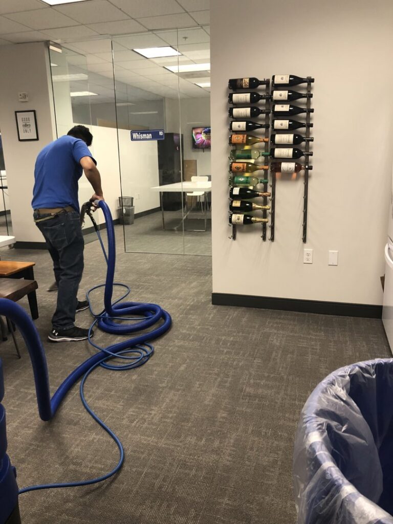 A technician performing commercial carpet cleaning in an office space with professional equipment for Dalia's Carpet Cleaning in San Francisco, CA.