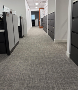 An open-plan commercial office area with cubicles and new grey patterned carpet installed by Rugs R Us Corporation in Fort Lauderdale, FL.
