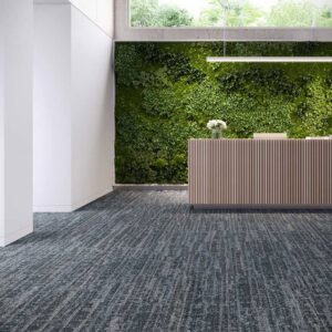 A modern commercial office reception area featuring patterned blue and grey carpet installed by Eastpointe Interiors in Caledonia, MI.