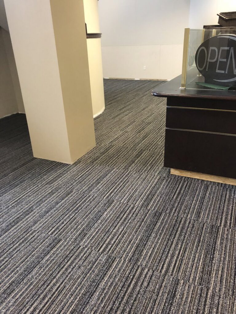 A commercial office space with newly installed striped carpet tiles by Grade A Flooring in Bronx, NY.