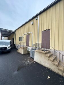 An outdoor air conditioning condenser unit next to a commercial building, serviced by Express Home Services LLC in Las Vegas, NV.