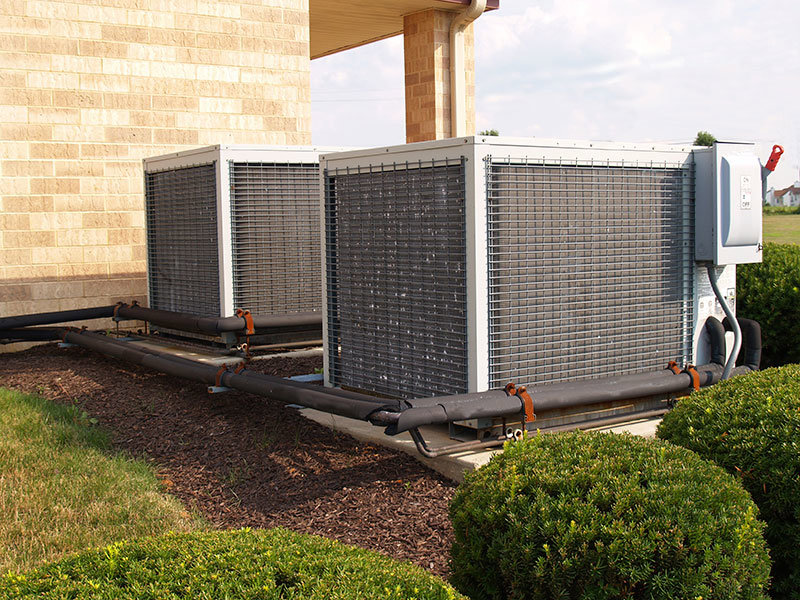 Two large commercial outdoor HVAC units installed next to a building, serviced by Mid-City HVAC, INC. in Chicago, IL.