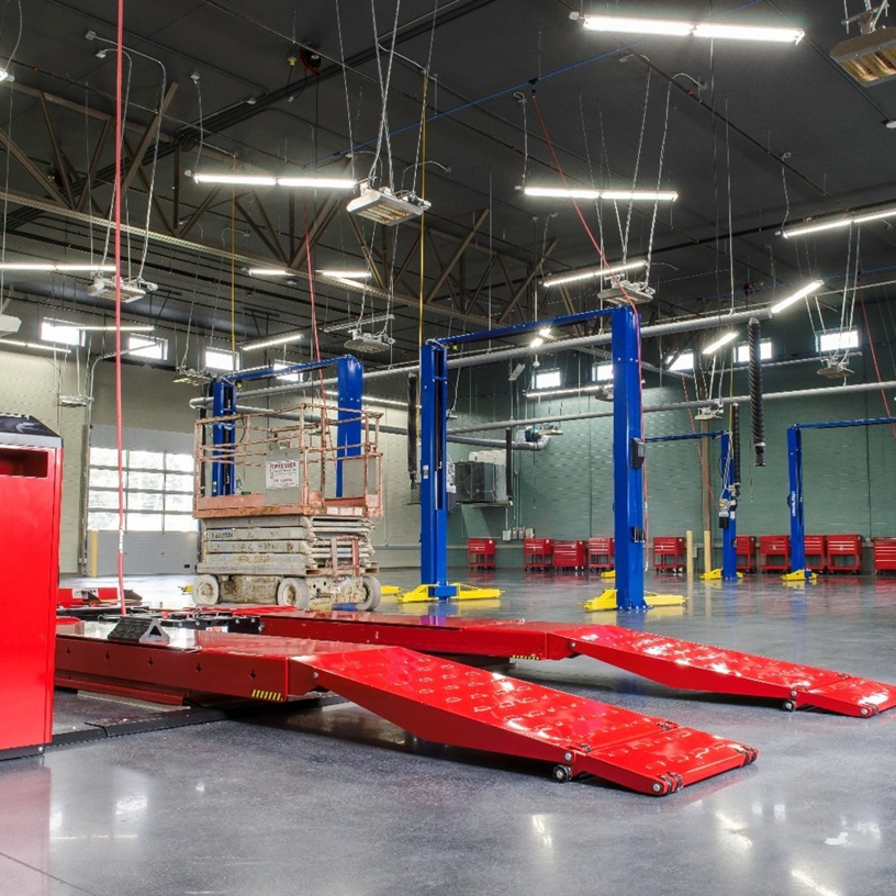 Interior view of a commercial garage with an overhead door and vehicle lifts, showcasing work by Harrison Construction Co., Inc. in Northport, AL.
