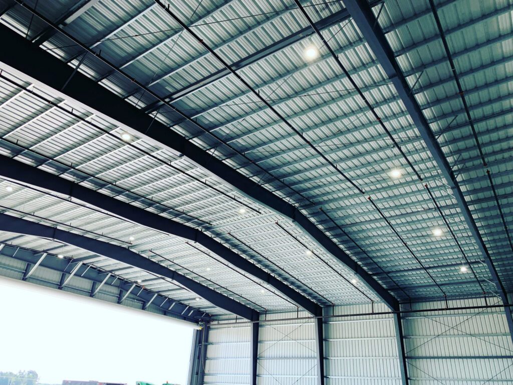 High ceiling of a large commercial building with numerous overhead lights installed by Harbour Electric in Wilmington, NC.