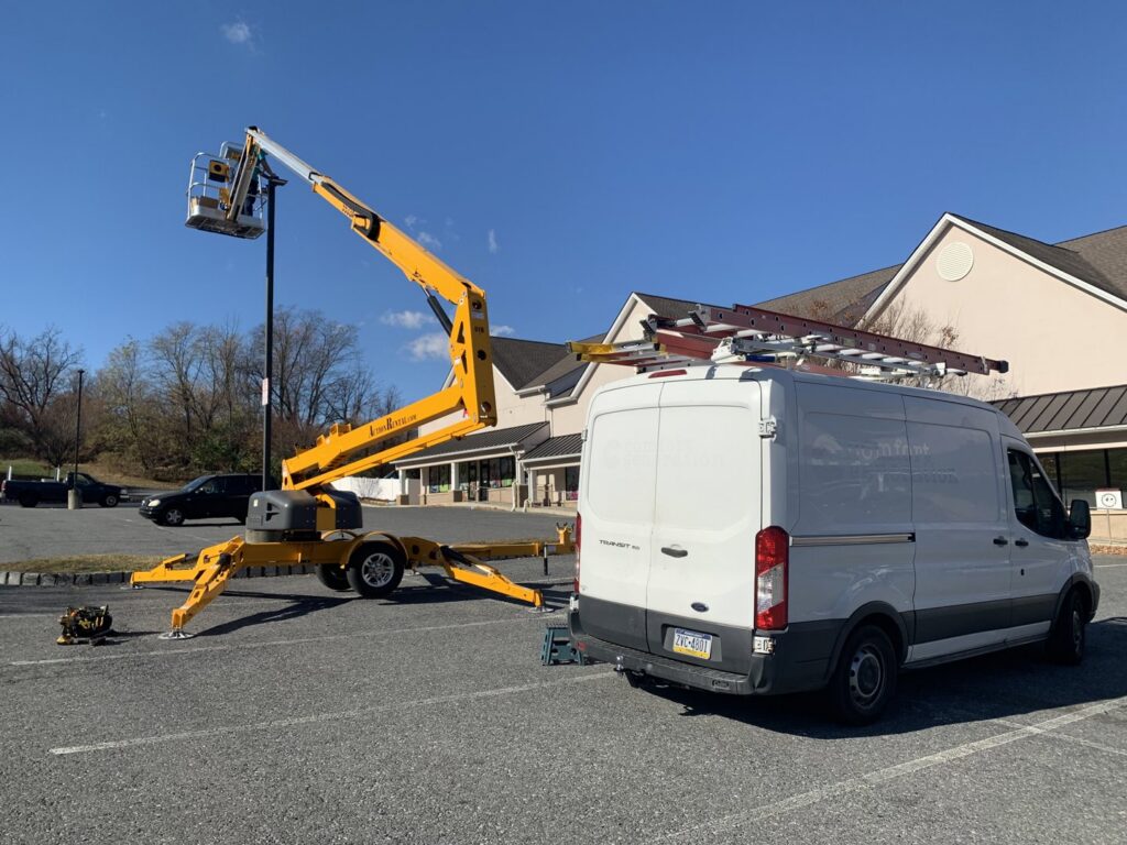 Commercial parking lot light repair using a boom lift by Civic Electric in Bethlehem, PA