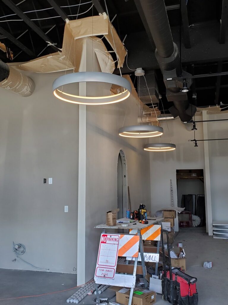Modern circular pendant lighting installed in a commercial space under construction by Johnsen Electric Inc in Springfield, OR.